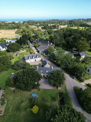 La Moinerie vue du ciel avec la mer au loin et le village de Plévenon à droite.