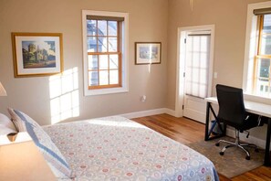 Bedroom with Oldest Wooden School House out the window and door to the balcony