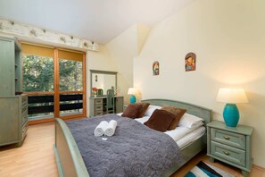 A bright and inviting bedroom with wooden furniture, a comfortable double bed, and soft lighting.