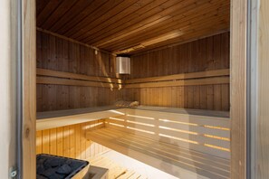 A traditional sauna room with wooden benches, ideal for relaxation.