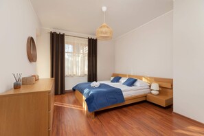 A bedroom featuring a wooden bed frame, bedside tables, and blue bedding, creating a warm and inviting atmosphere.