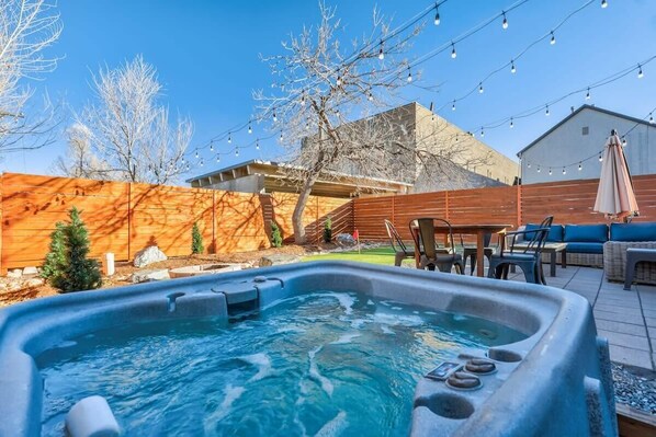 Enjoy the Hot Tub, Putting Green, a cozy Fire Pit, a sizzling Grill, a comfortable Couch, and a stylish Patio Table.