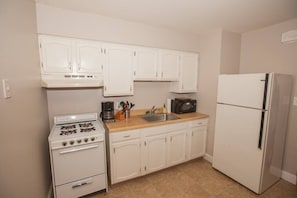 Fully stocked kitchen, coffee maker, range, microwave and full size fridge. Not Pictured is a kitchen table