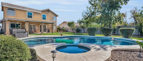 Unheated pool & Unheated Jacuzzi in large backyard with natural grass.