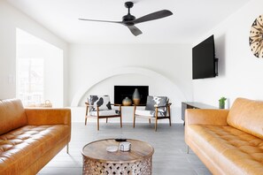 living room with 2 leather couches and 65" Roku tv