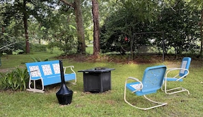Backyard seating area with gas grill and gas fire pit.