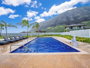 Blue pool with palm trees and epic mountains—Hawaii perfection!