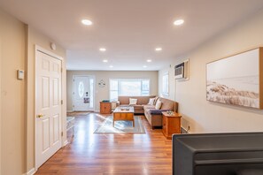 The View from the dining area into the open living room behind the smart TV.