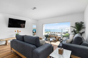 Cozy living room with TV and amazing beach view.