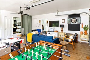 game room with arcade games, foosball, air hockey, darts, 50" TV with yoga mats