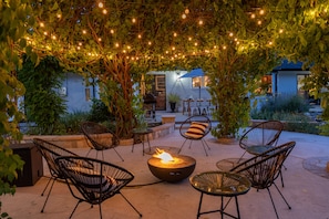 relax around the fire pit under the vine covered gazebo