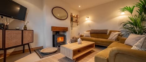 Maurice Cottage: A cosy sitting room with wood burning stove