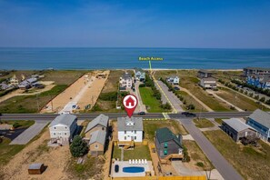 Aerial showing how close the public beach access is. Enjoy hanging by the pool, hot tub or beach all without driving a inch. Hot tub is not shown in this photo but is in back yard near black dining table. 