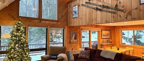 Main floor vaulted living space with expansive windows and fireplace