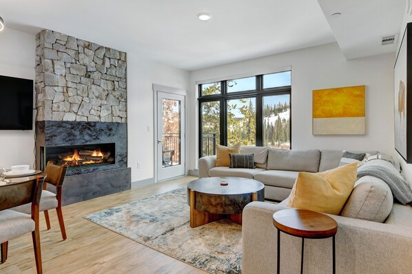 Spacious Living Room With 60" HD TV And Custom Color Changing Fireplace To Set The Ambiance