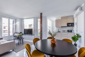 View of living room space with the background and dining room and kitchen space