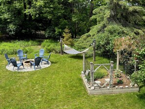 EXTERIOR:  The gorgeous backyard with fire pit, hammock, and herb garden