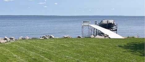 Dock with boat lift and bench seat.