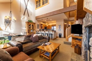 Living area with gas fireplace, vaulted ceiling, access to the private balcony and cozy furniture.