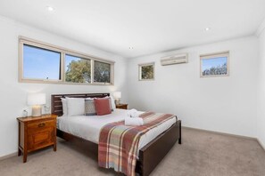 The master bedroom upstairs is a private oasis with a Queen bed, reverse cycle air conditioning, and ensuite