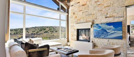 Great room is accented by a vaulted ceiling & cozy fireplace with stone wall.