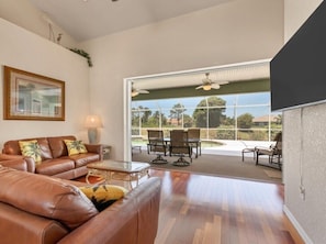 Living room doesn't disappoint with panoramic sliders directly out to the pool and lanai.