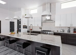 Fully equipped kitchen stocked with your basic cooking essentials, oversized island/breakfast bar and stainless-steel appliances.