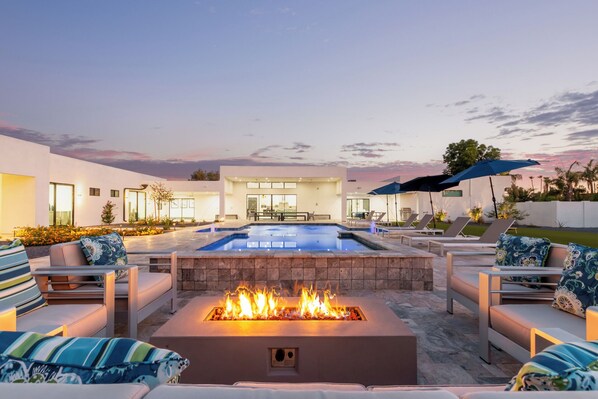 Stunning resort-style spacious yard featuring a Pool, Spa, Sun Loungers, Firepit, Putting Green, Ping Pong, Cornhole and ample yard space.