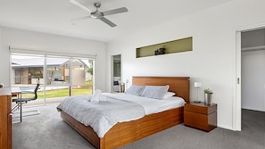 Master Suite: King Bed with ensuite, ceiling fan, air conditioning, small TV, desk, walk-in-robe, and pool views.