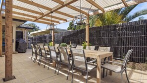 Outdoor dining for 14 under a shaded pergola