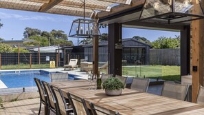Outdoor dining overlooking pool and fully fenced garden area