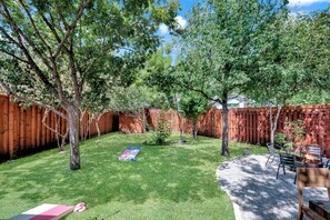 Backyard has cornhole, fire pit, firewood included, and a dining table