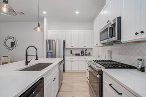 Bright and white with plenty of lighting, this fully equipped kitchen has all the best bells and whistles for your cooking pleasure, including a breakfast bar!