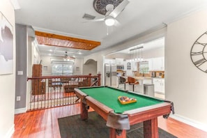A pool table to play and enjoy with easy access to the living room and kitchen