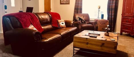 Living area with leather couch and recliners.