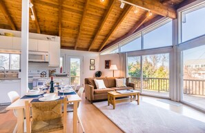 Living room/dining area with stunning natural light throughout the sliders.