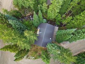 Aerial Serenity: Gazing Down on a Cozy Cabin Nestled Amidst Nature's Beauty. 🌲🏡🌞 #CabinRetreat