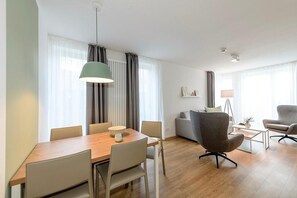 Wohn-Essbereich mit Esstisch, Sitzgelegenheit und Küchenzeile