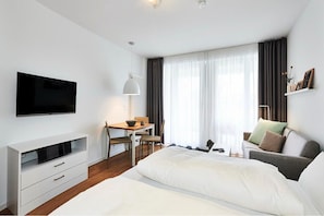Wohn/Essbereich mit Doppelbett, Couch, Esstisch und TV