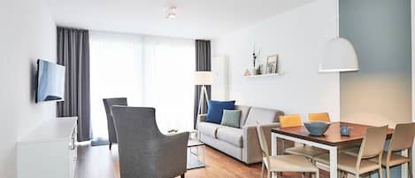 Wohn/Essbereich mit Esstisch, Couch, Sesseln und TV