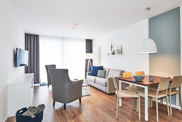 Wohn/Essbereich mit Esstisch, Couch, Sesseln und TV