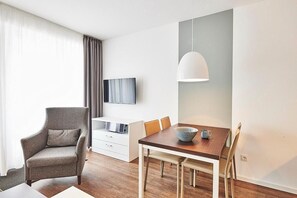 Wohn/Essbereich mit Sessel, TV und Esstisch