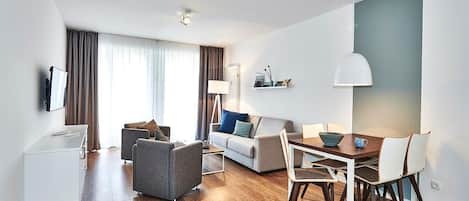 Wohn/Essbereich mit Sesseln, Couch, Esstisch und TV