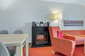 Wohnbereich mit Sofa, Sessel, Couchtisch und Kamin