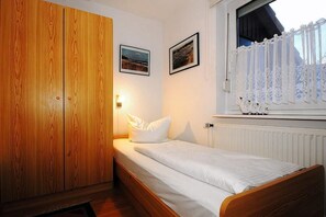 Schlafzimmer mit Einzelbett und Kleiderschrank