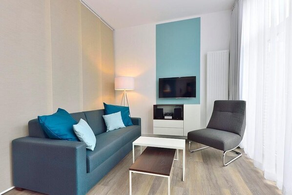 Wohn/ Essbereich mit Couch, Sessel und Fernseher