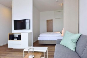 Wohn/ Essbereich mit Couch, Tisch und Fernseher