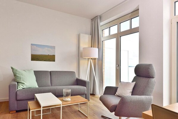 Wohn/ Essbereich mit Couch, Sessel und Tisch