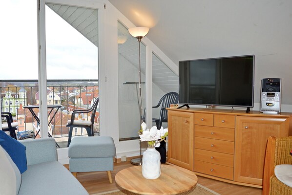 Wohnbereich mit Flatscreen TV und Zugang zum Balkon