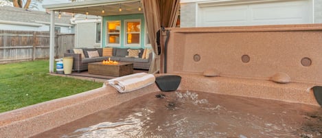 hot tub and patio with fire pit